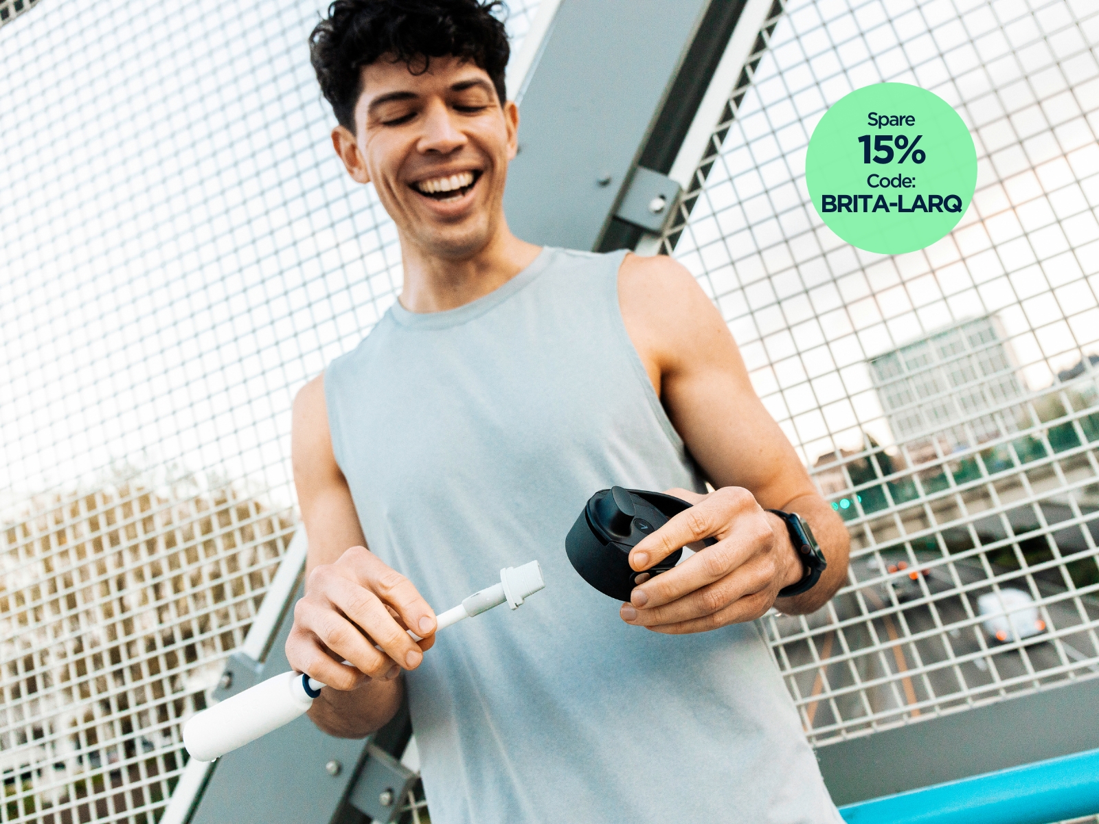 Ein junger Mann im Sportoutfit hält den Deckel und den Filter Straw der BRITA LARQ iQ in der Hand.
