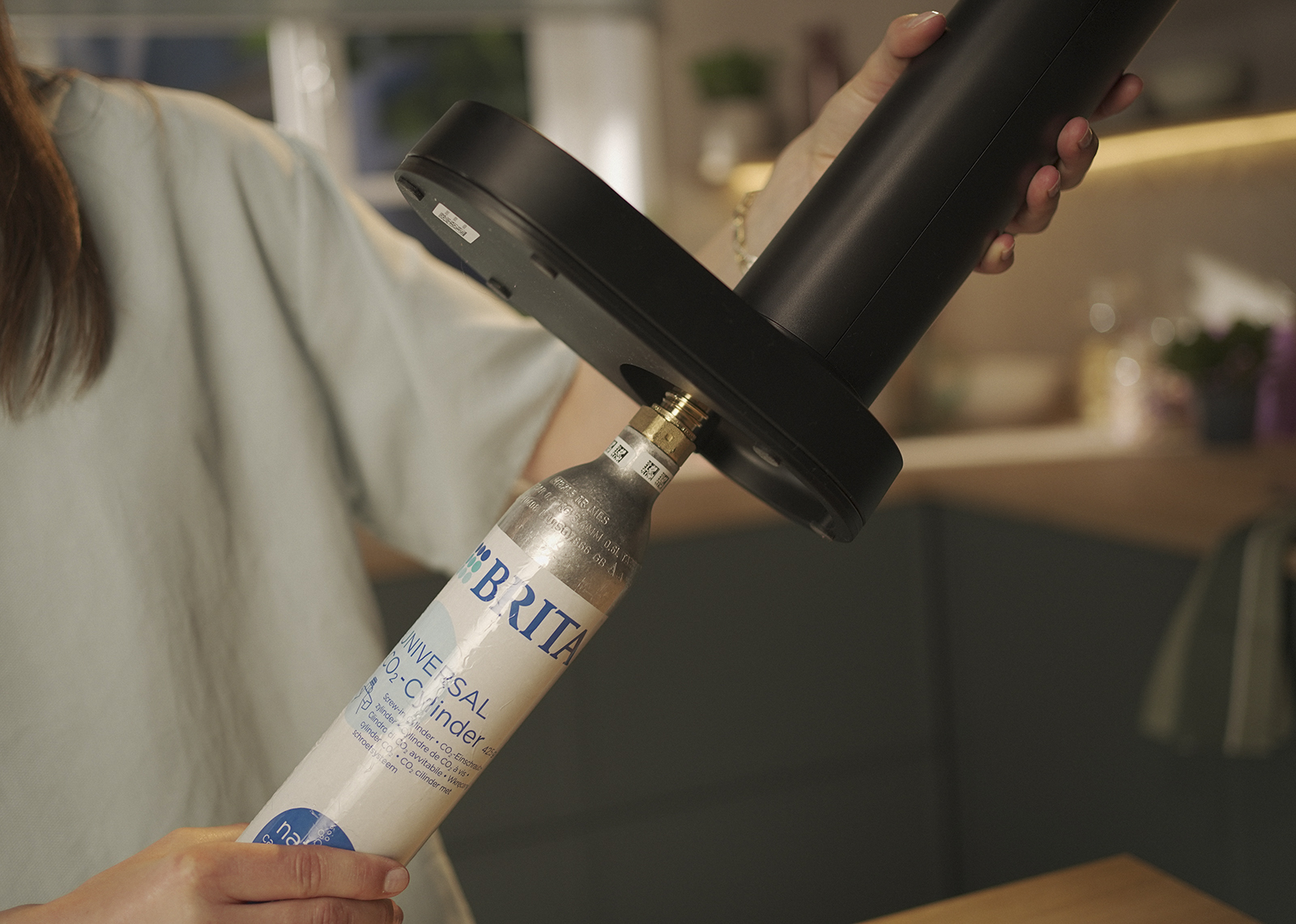 Ein Mann setzt einen CO2-Zylinder in den schwarzen BRITA sodaONE ein