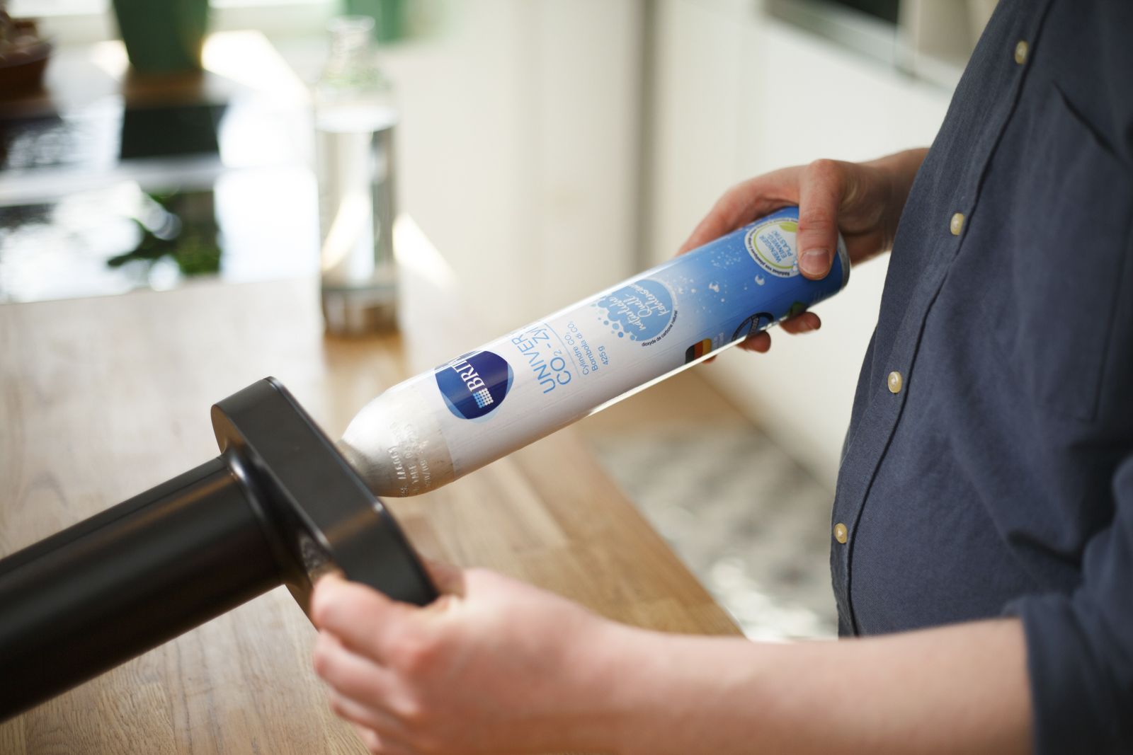 Mann setzt CO2-Zylinder in den BRITA sodaONE ein Ein Mann setzt einen CO2-Zylinder in den schwarzen BRITA sodaONE ein