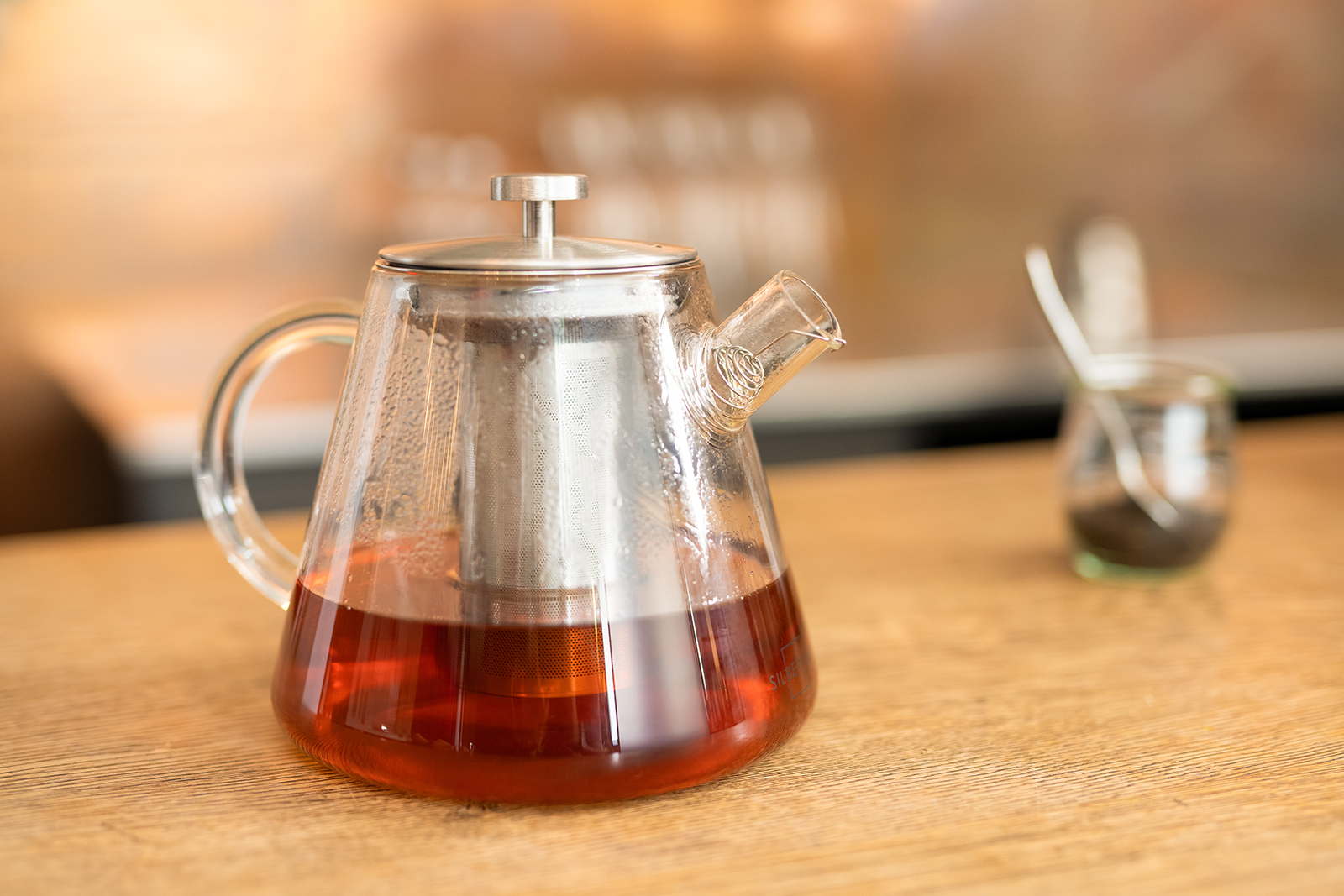 Klarer, rötlicher Tee in einer Teekanne aus Glas