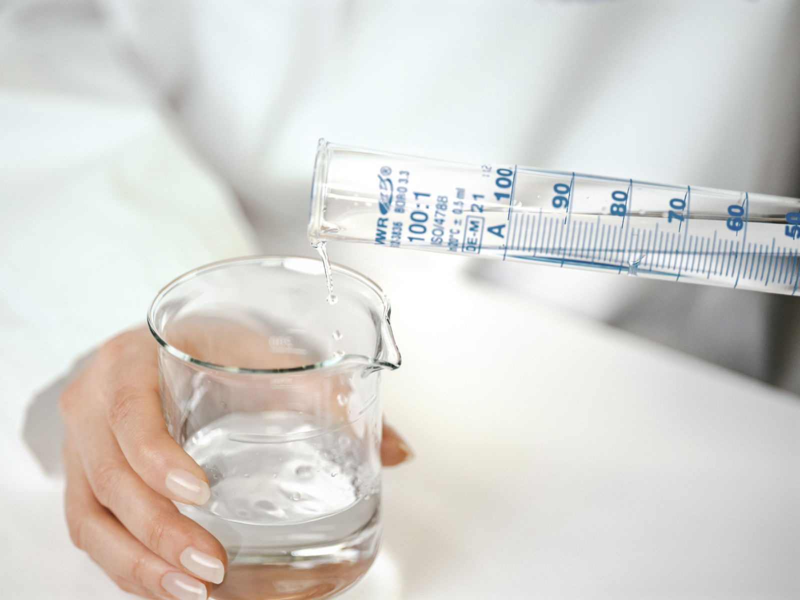 Wasser Test im BRITA Sensorik Labor Flüssigkeit wird aus einem Reagenzglas in ein größeres Gefäß umgefüllt